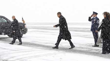U.S. President Obama makes his way from Air Force One to his motorcade upon his arrival during a snowstorm in Manchester